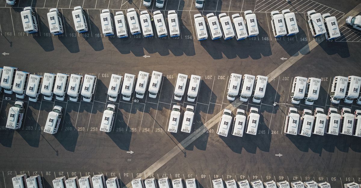 Aerial perspective showcasing a parking lot filled with parked camper vans.